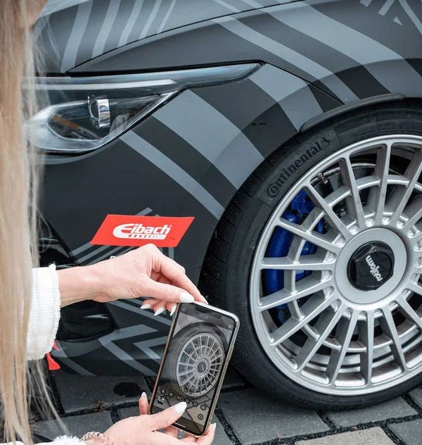 A person taking a picture of a Continental car tire