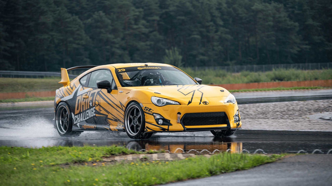 A yellow sports car on a wet road 