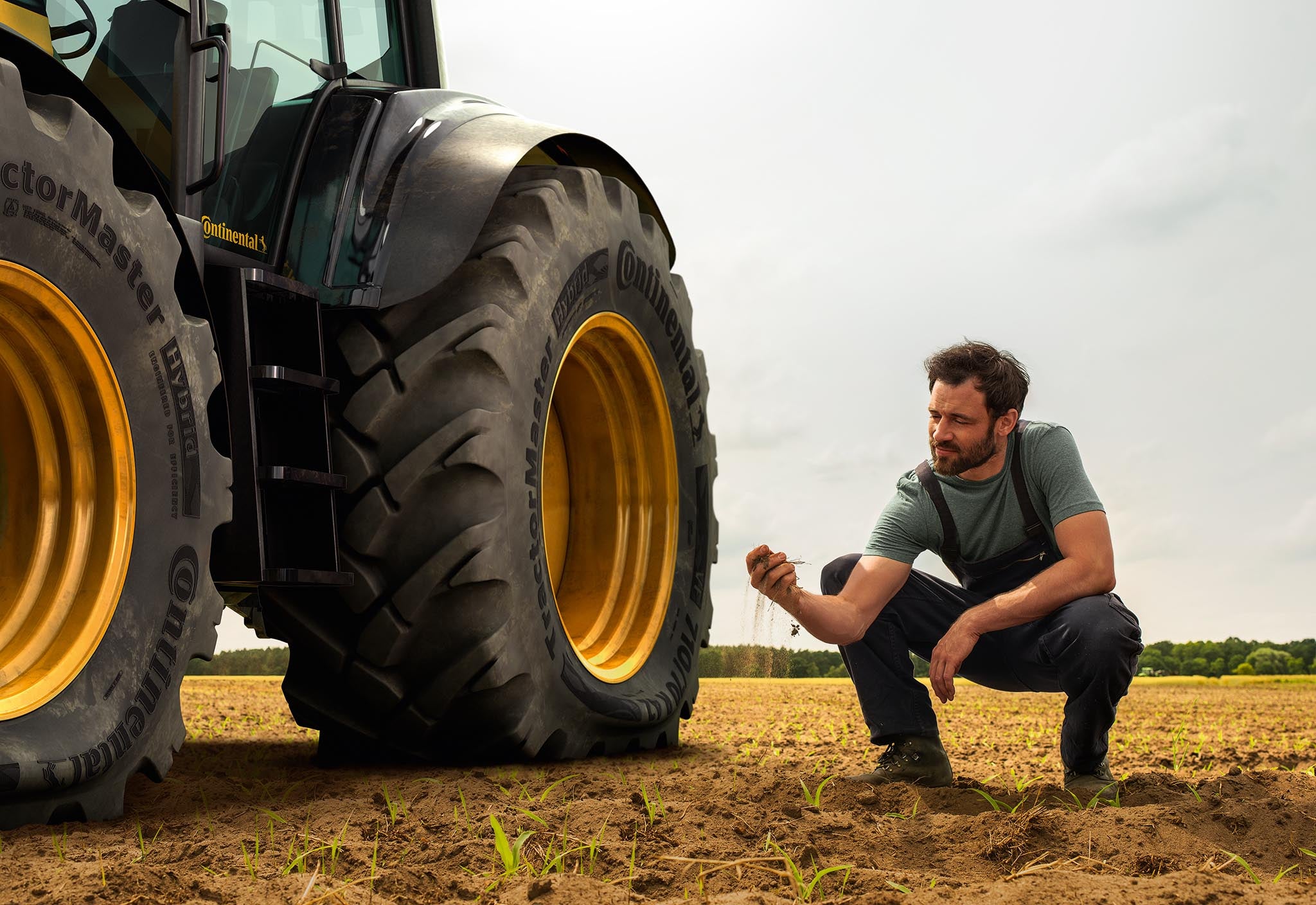 Ein Mann in der Hocke neben einem Traktor