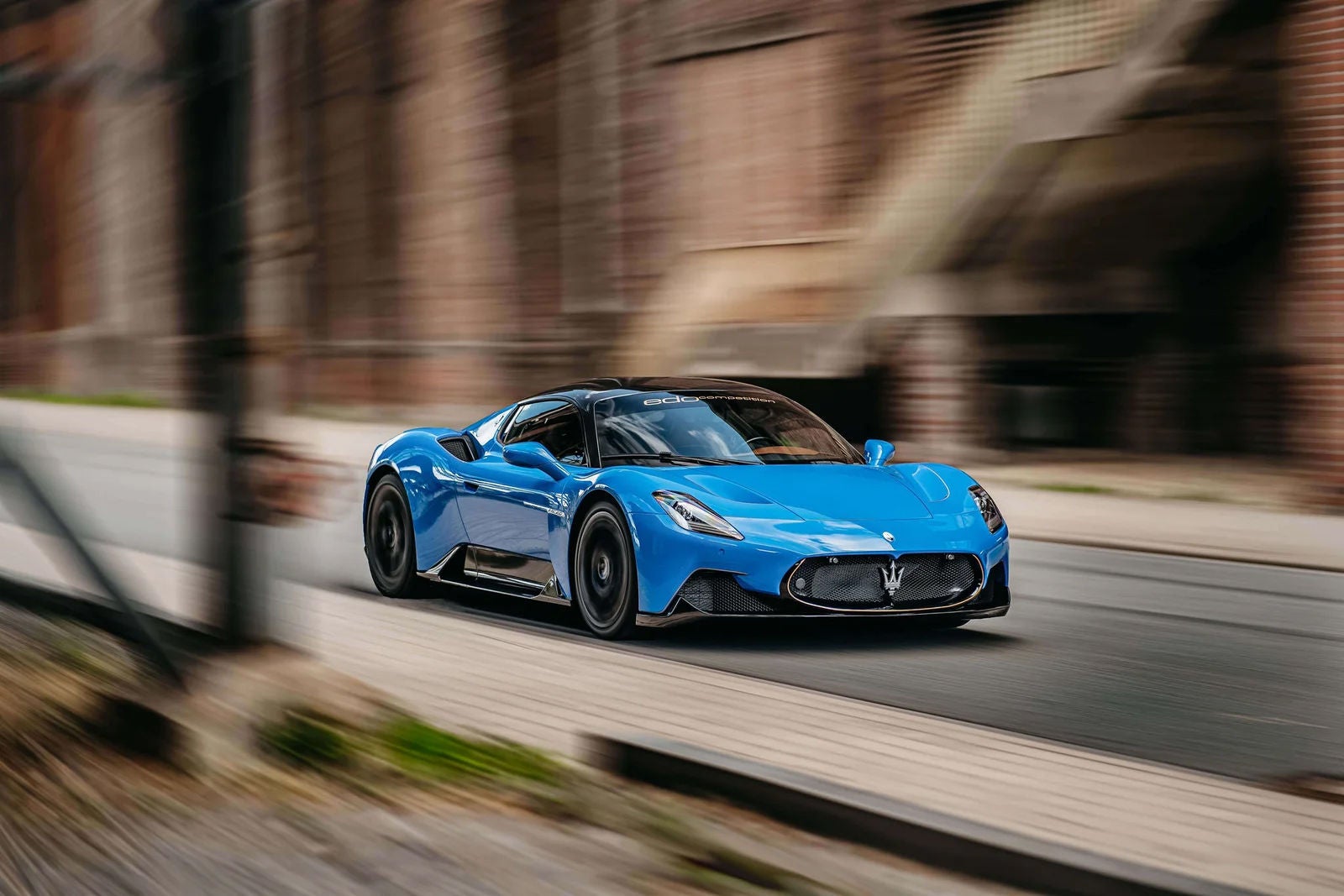 A blue sports car on a street 