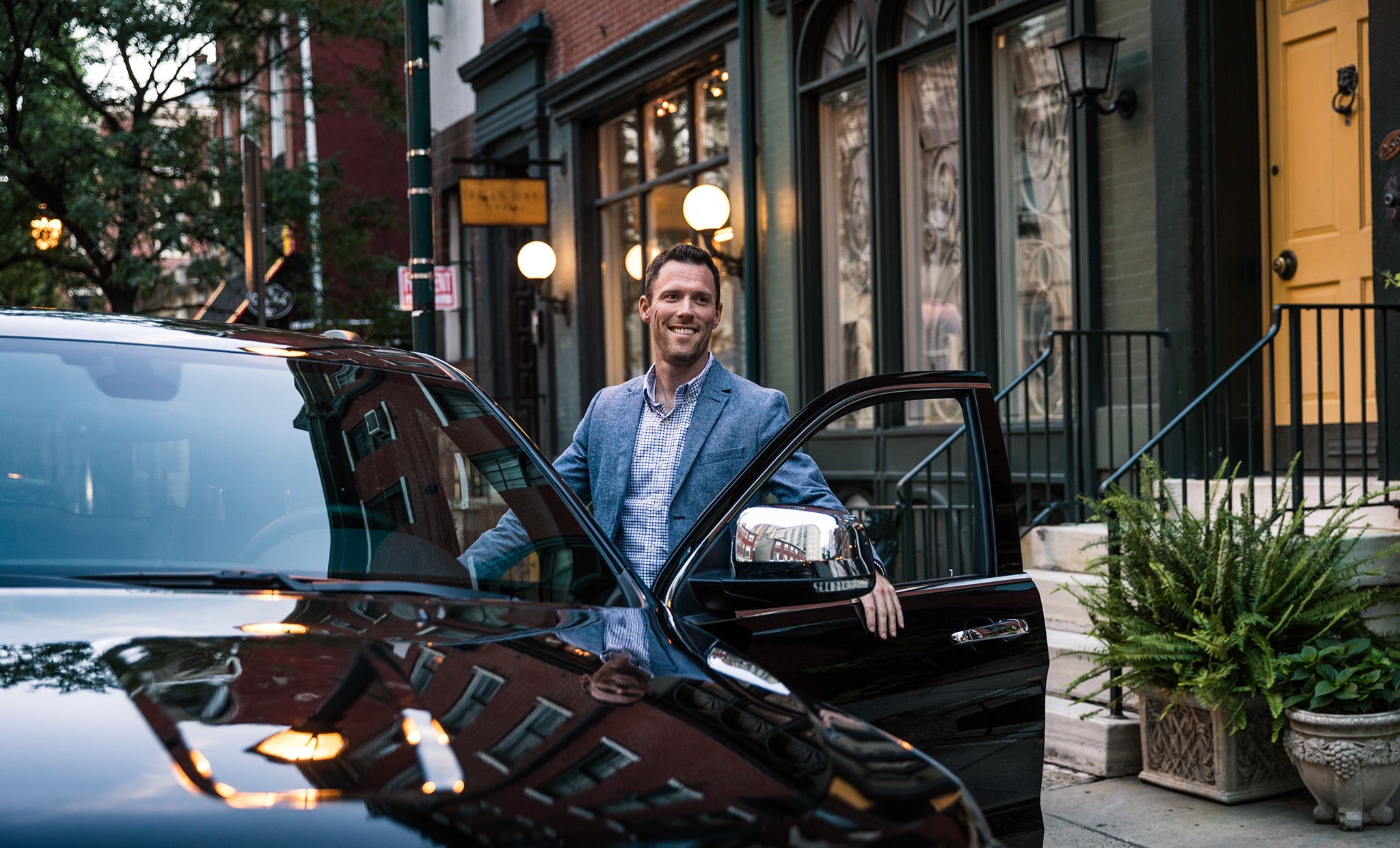 A man standing next to his car with the door open.