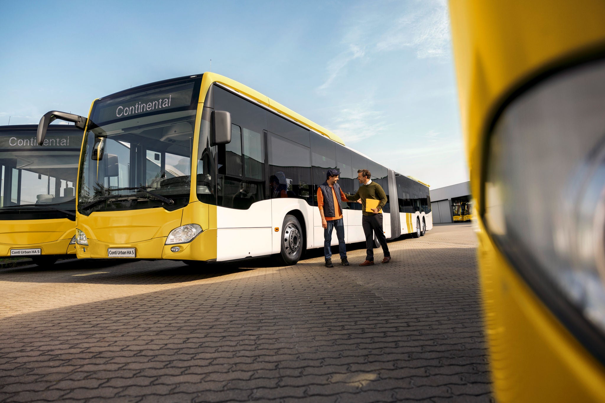 Fleet manager en bus chauffeur op de busstop.