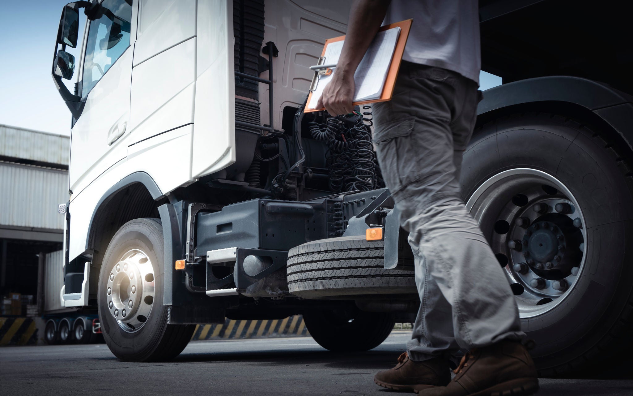 Truck Driver is Checking the Truck's Safety Maintenance Checklist. Repairman Auto Service Shop. Lorry Fixing. Truck Inspection Safety of Semi Truck Wheels Tires.	; Shutterstock ID 2135259837; purchase_order: -; job: -; client: -; other: -